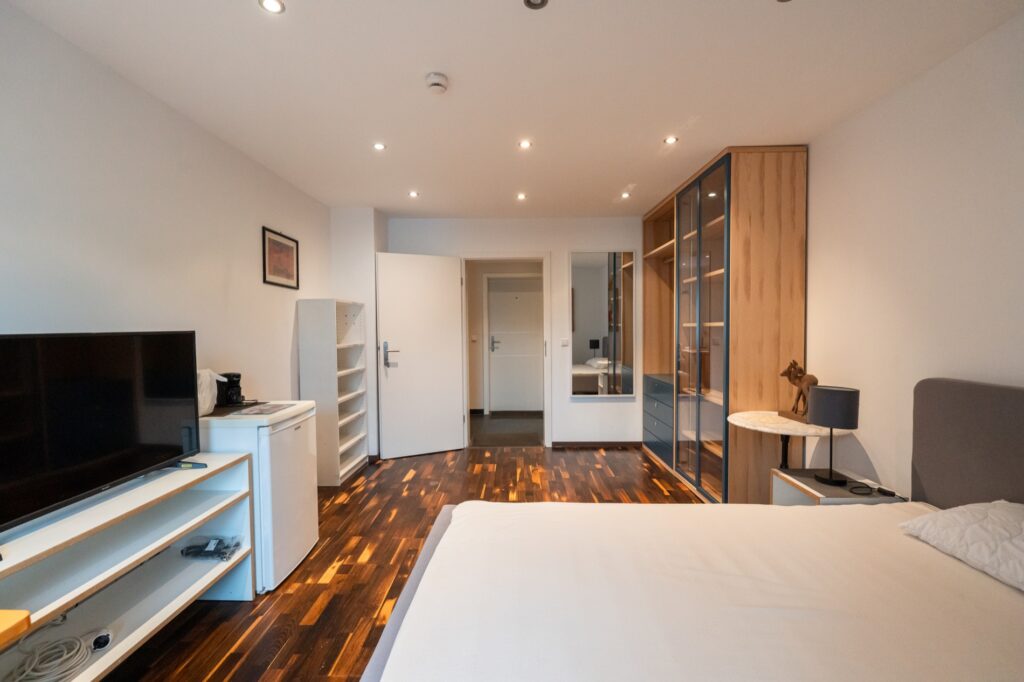 Blick in ein möbliertes Zimmer mit Schrank und Sitzbereich